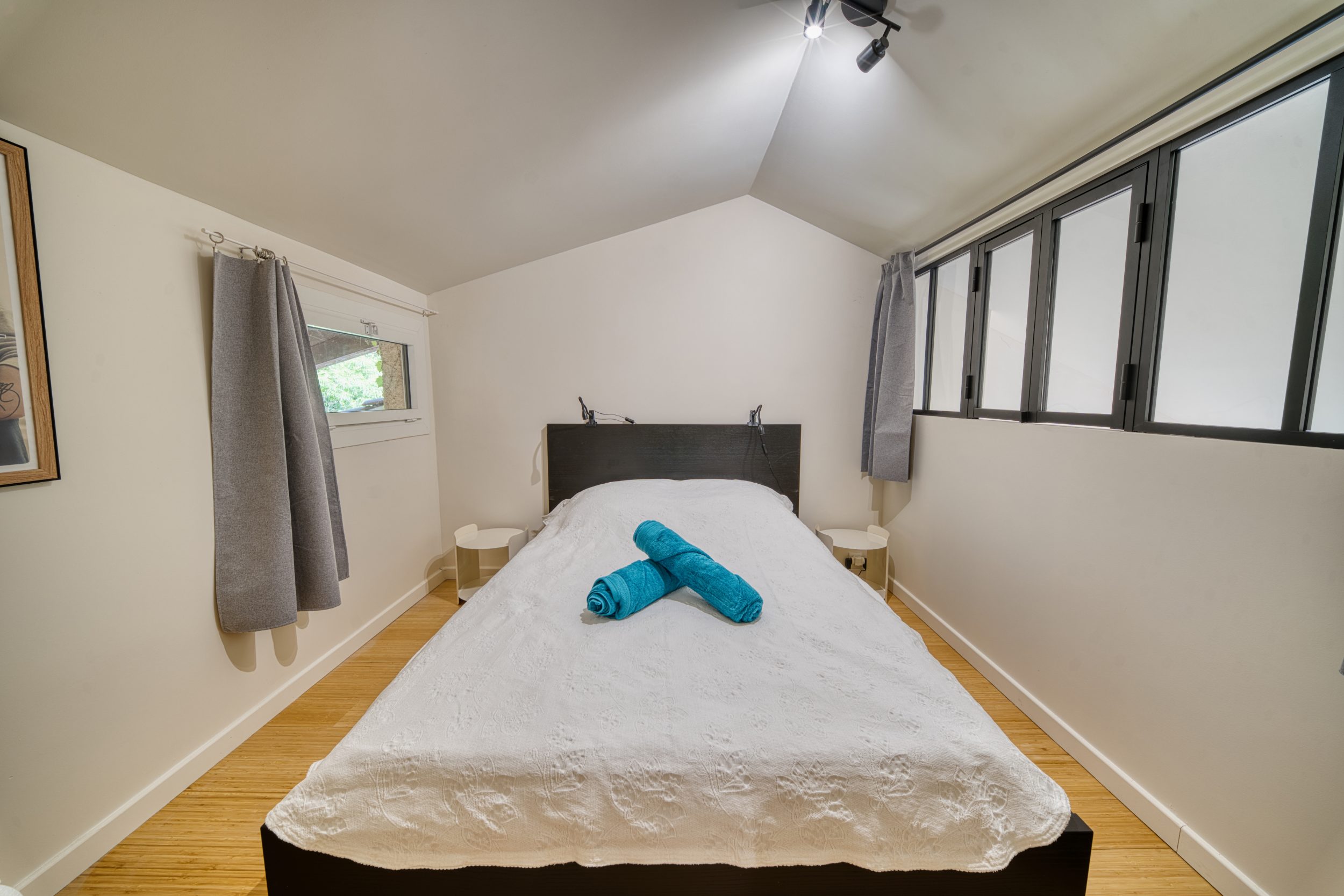 Chambre mansardée au lit double, sous verrière
